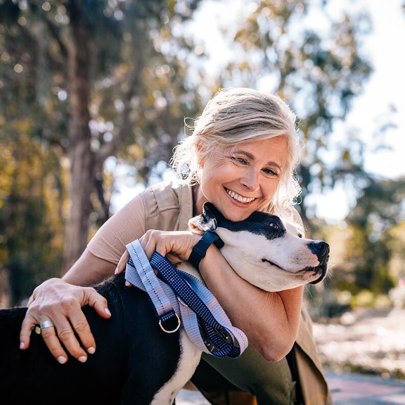 Affectionate Mature Woman Embracing Pet Dog